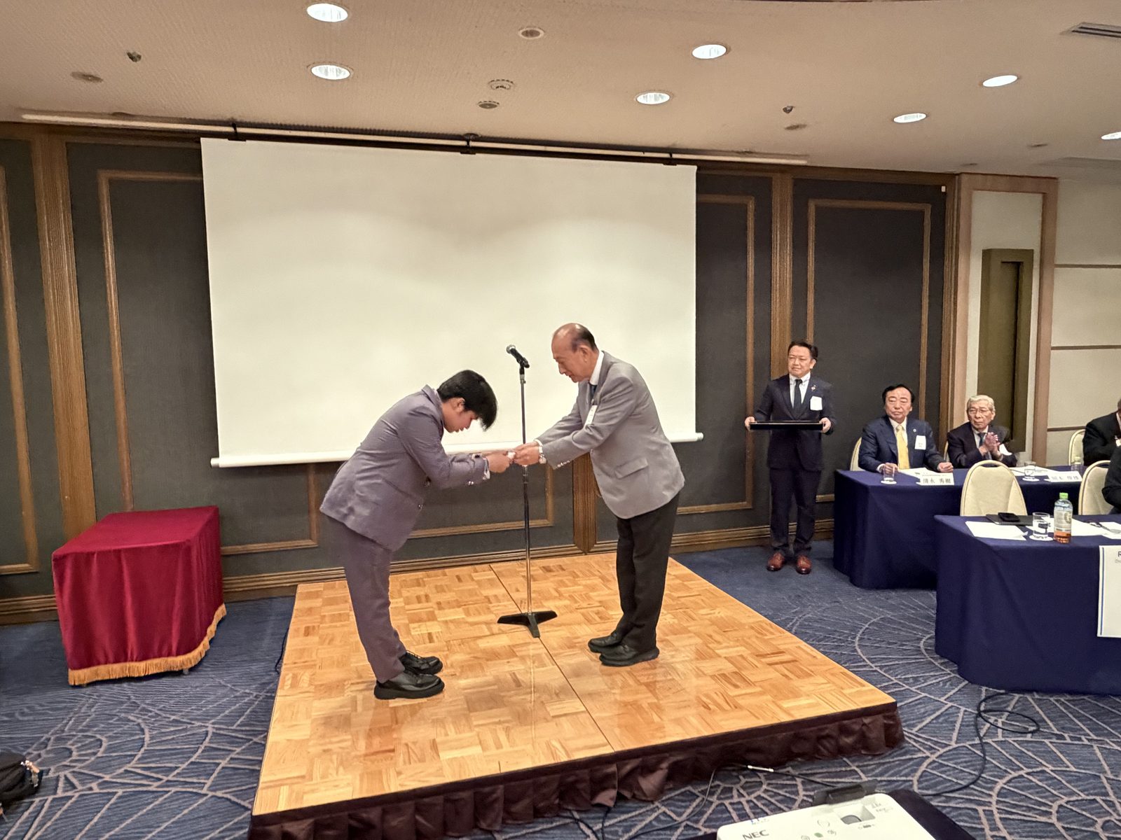 Receiving the Rotary Yoneyama scholarship certificate on stage